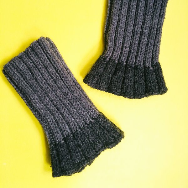 Pair of knit legwarmers flatlay on yellow background