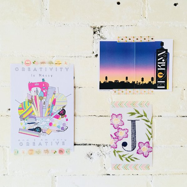 Three postcards taped to white wall with washi tape